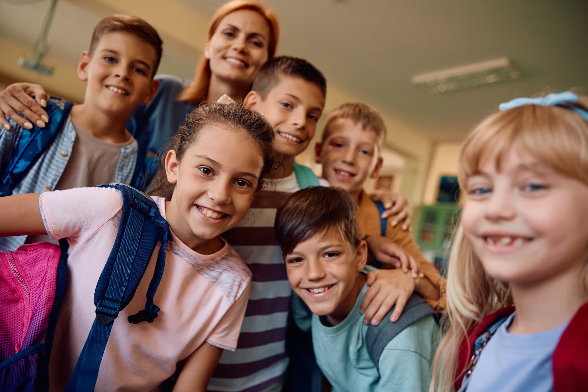 Smiling students with their teacher in a classroom