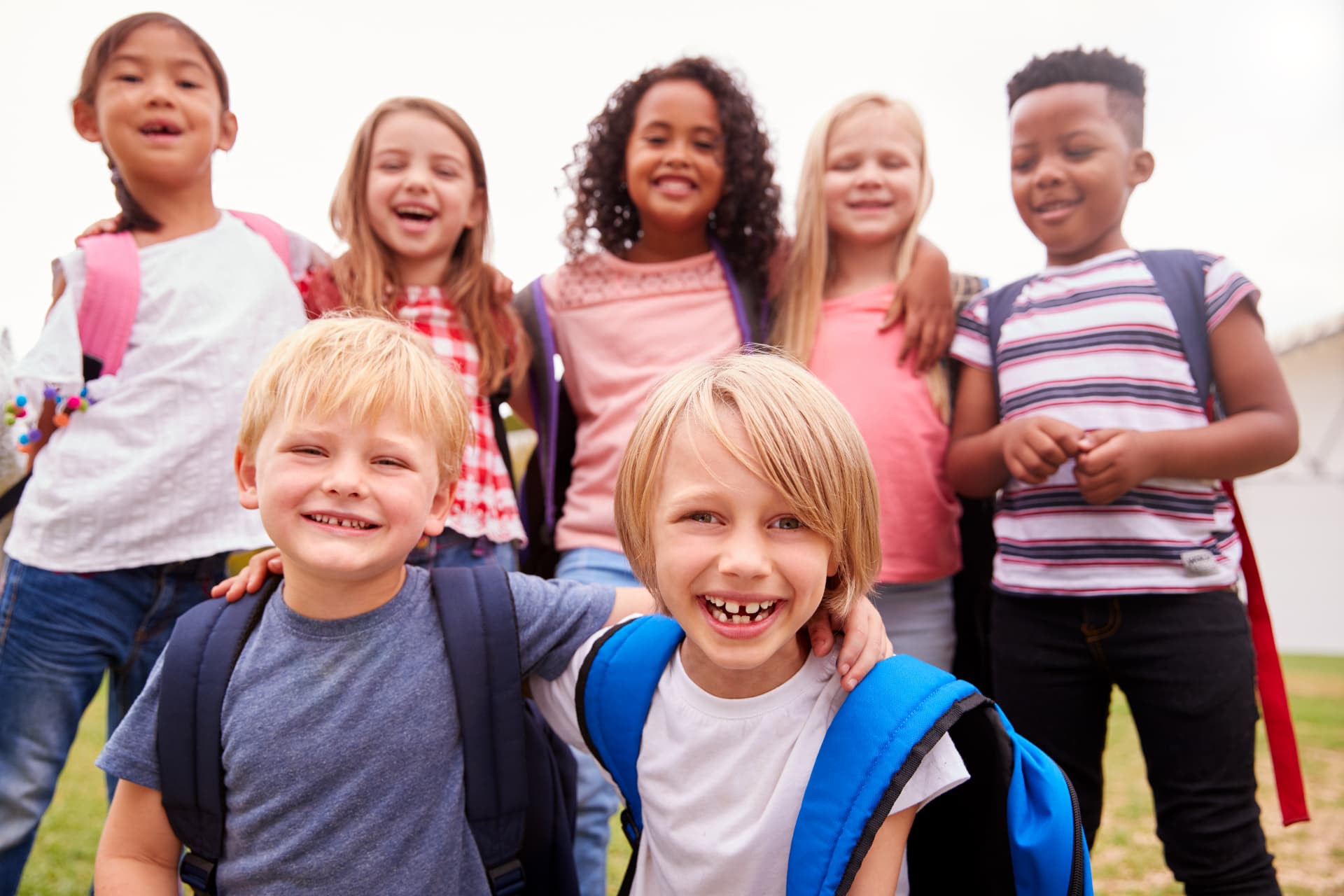 Excited elementary school students together outside on the playground